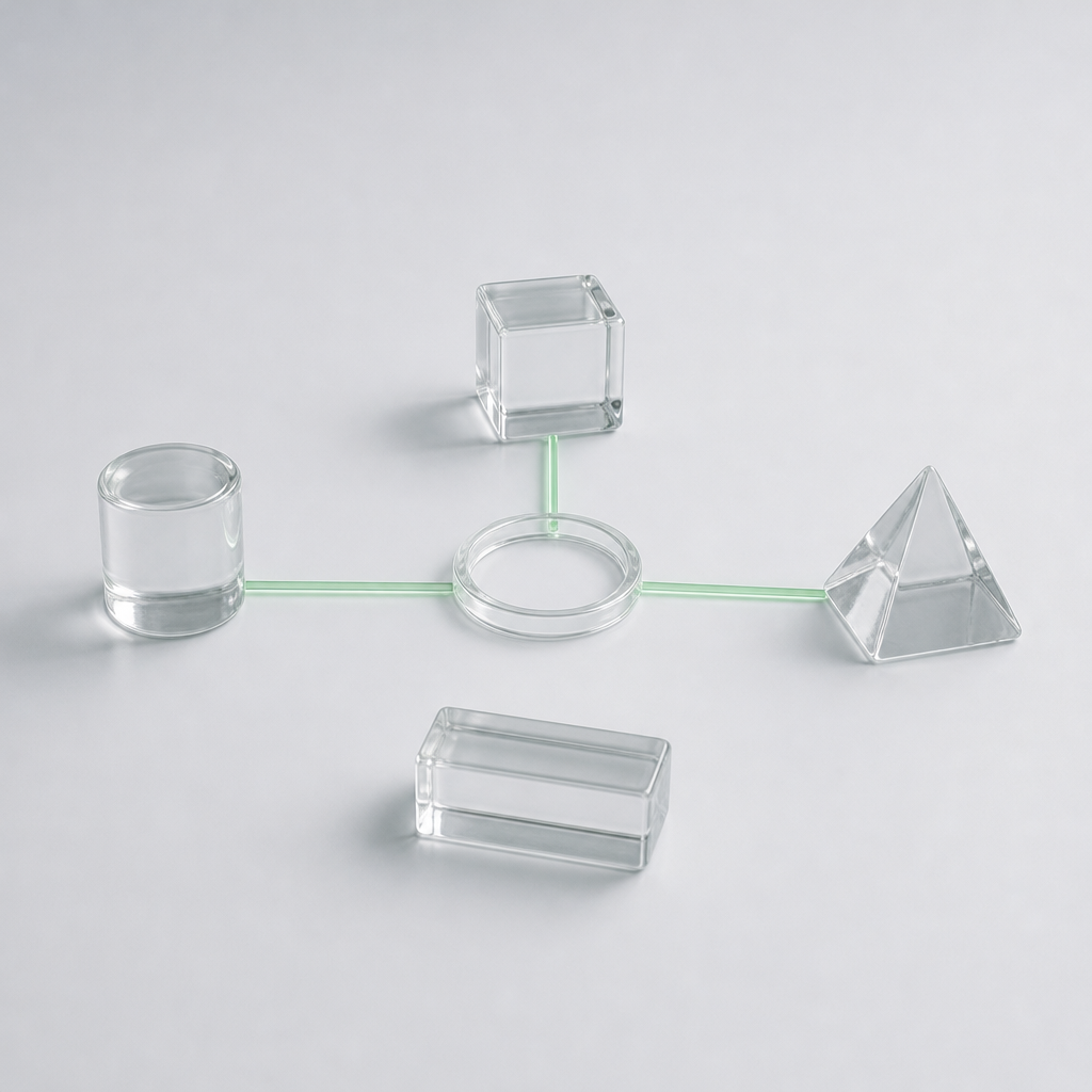 Four clear glass blocks of different shapes on a pale grey surface, three joined to a central ring by thin green lines.